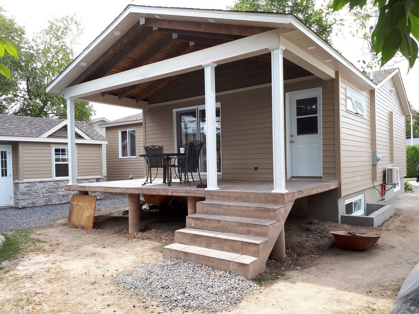 Une petite maison avec un porche et des escaliers