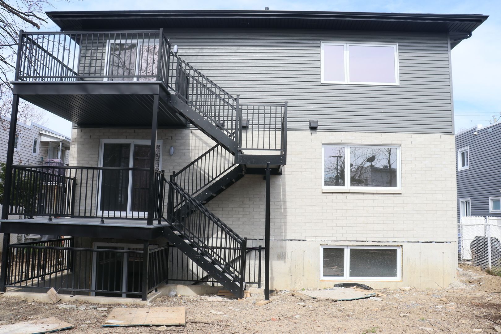 L'arrière d'une maison avec des escaliers et un balcon.