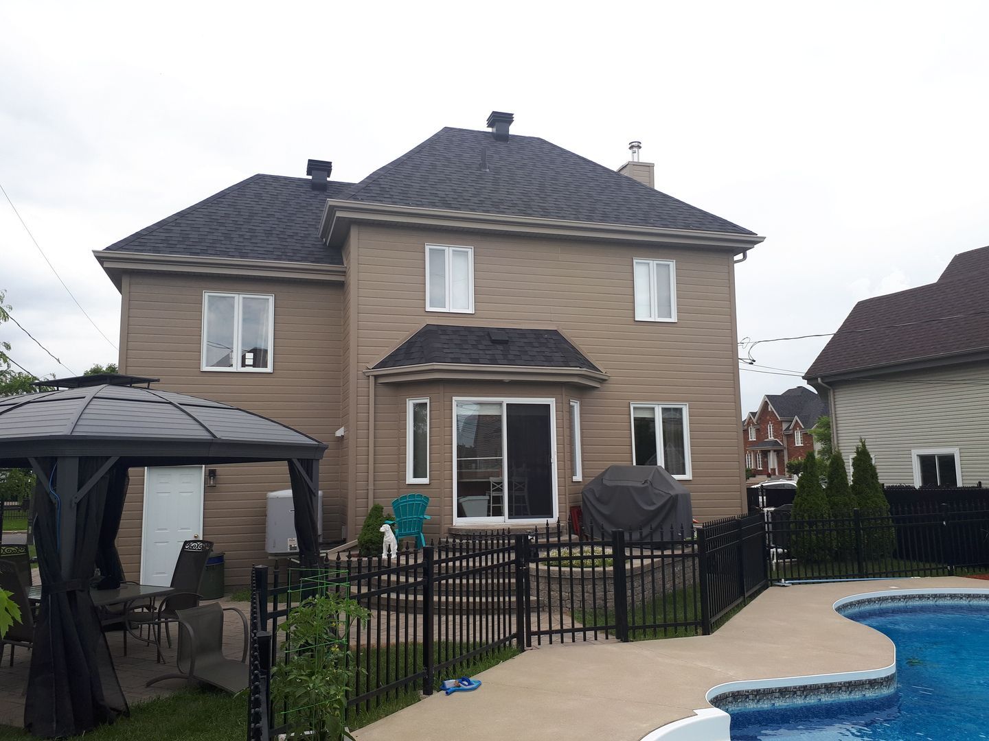 Une maison avec un belvédère et une piscine devant