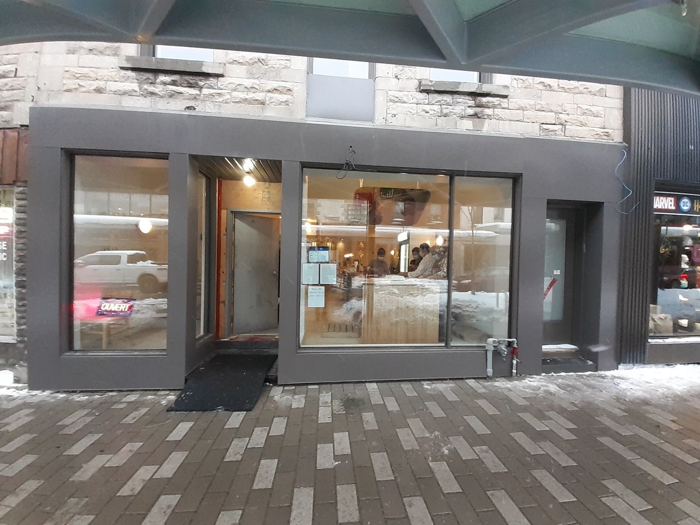 Une devanture de magasin avec une allée en briques qui y mène