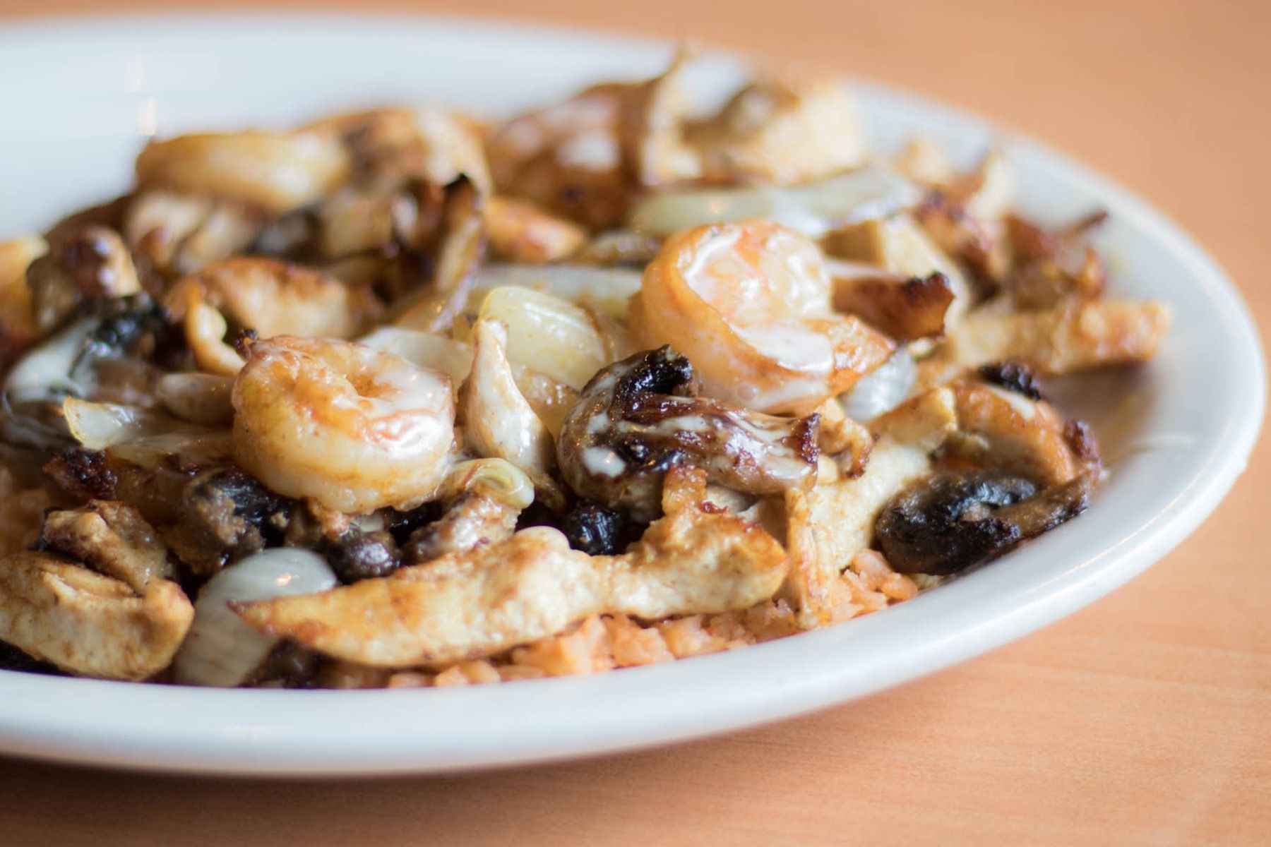 Plate of sauteed shrimp, onions, mushrooms, and chicken.