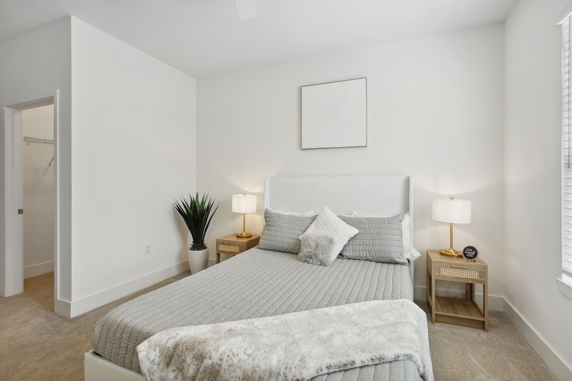Bedroom with bed, two bedside tables, and a plant.