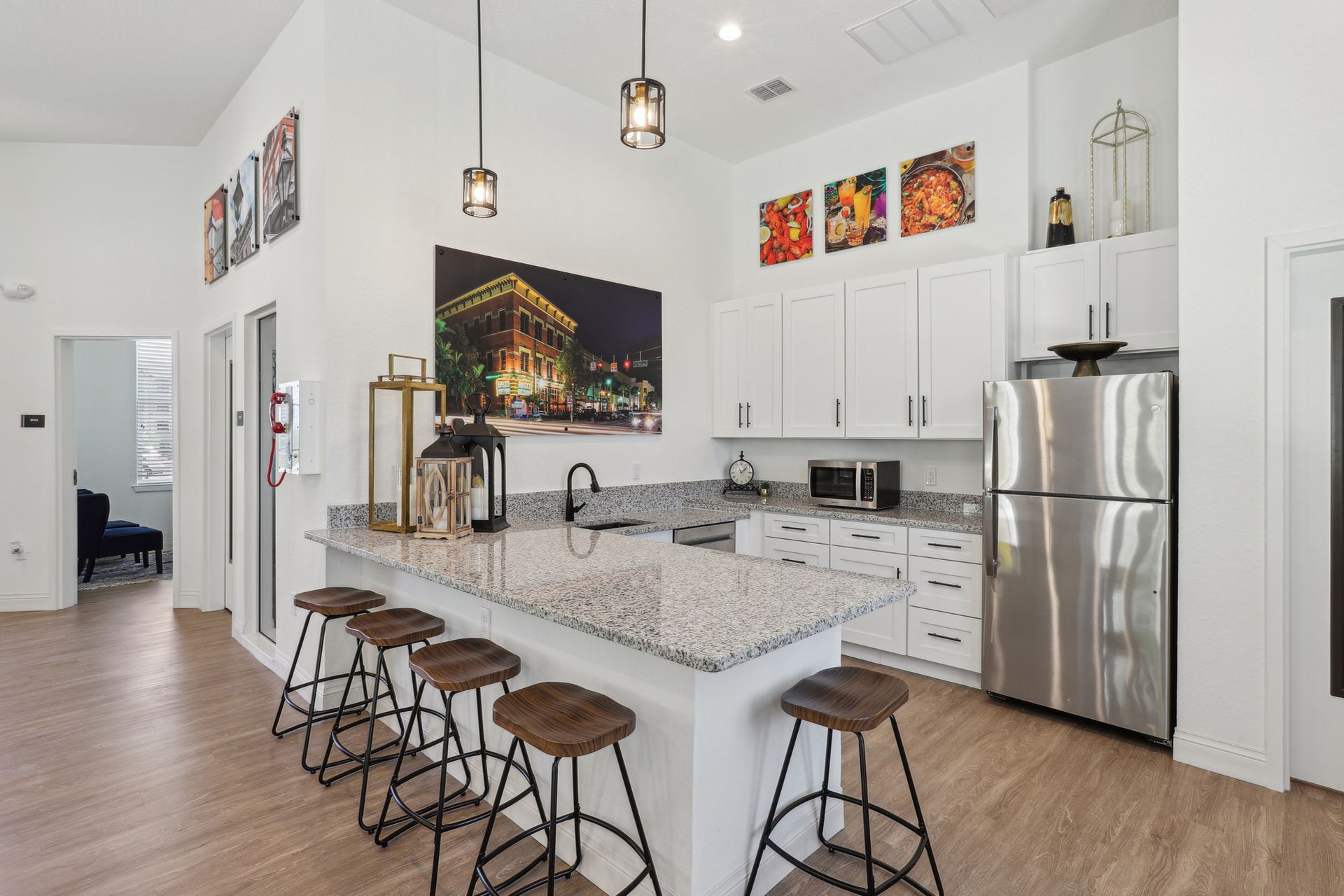 Kitchen with granite countertop island, stainless steel appliances, and white cabinets.