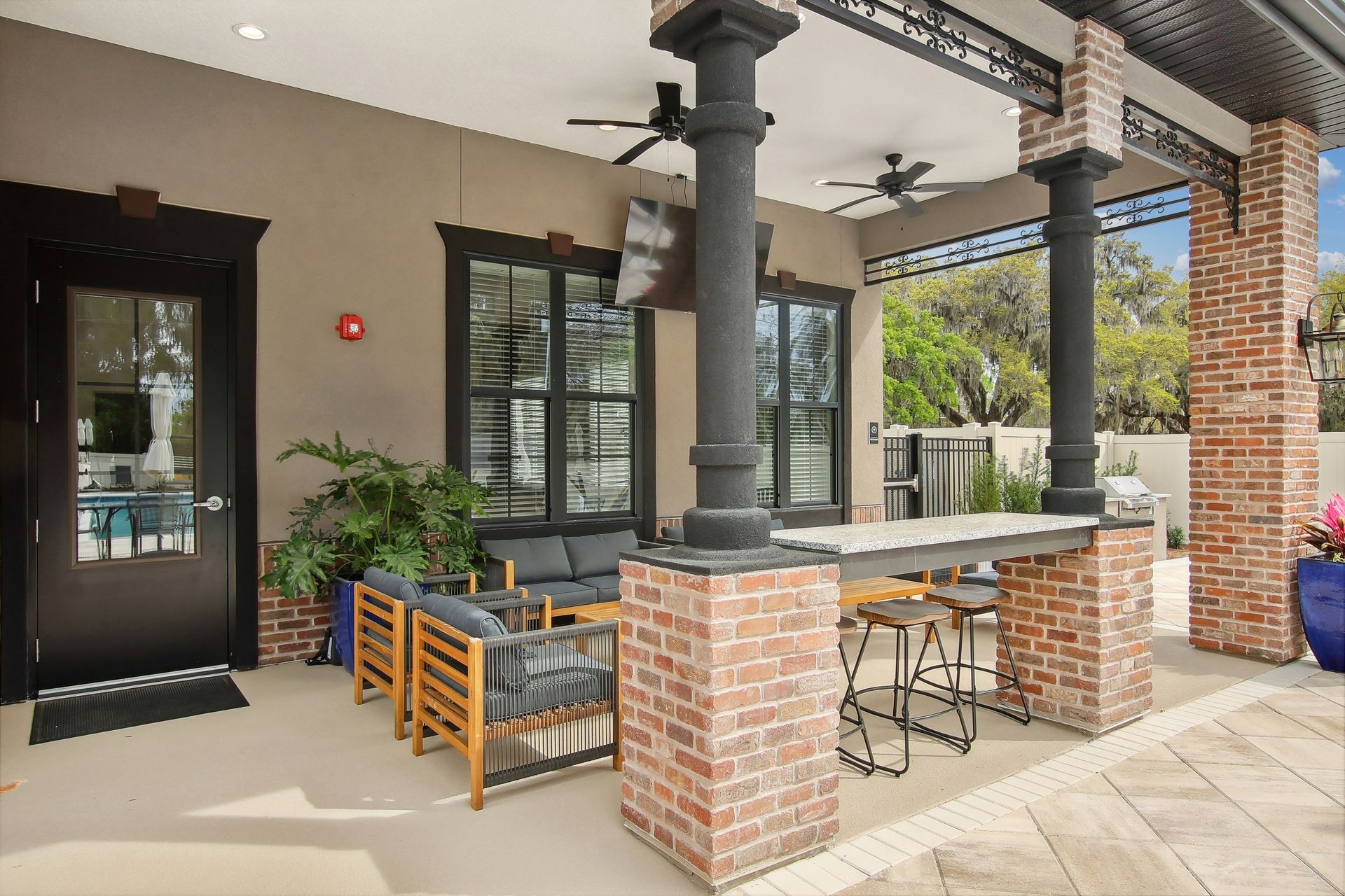 Outdoor patio with brick columns, seating, and a bar.