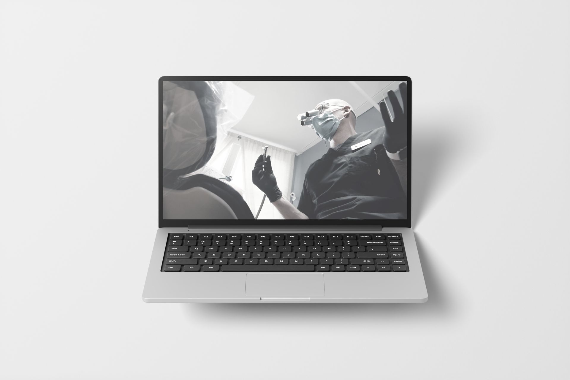 Laptop displaying a dentist examining a patient's mouth.