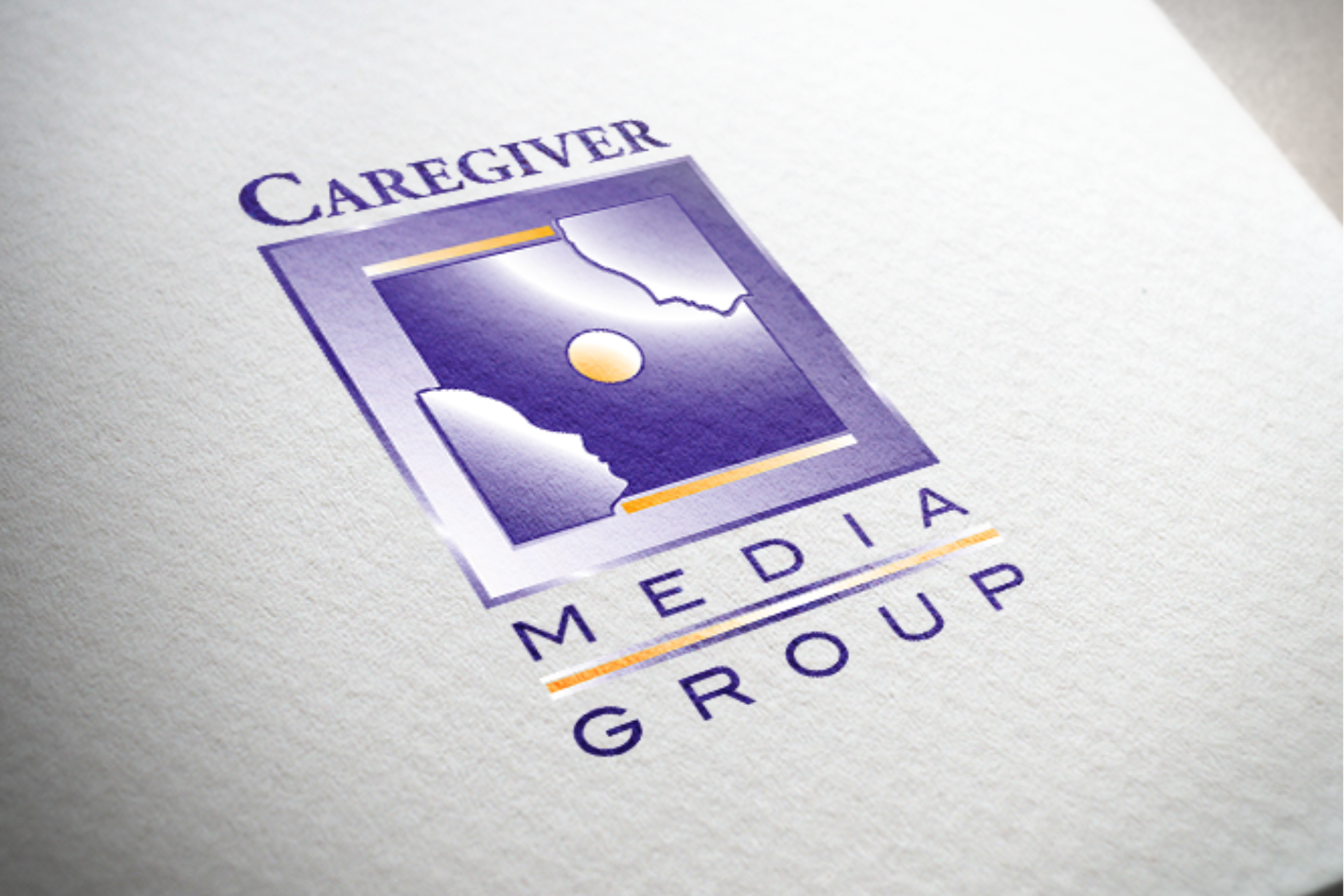 Logo for Caregiver Media Group, purple and gold square with abstract design and company name.