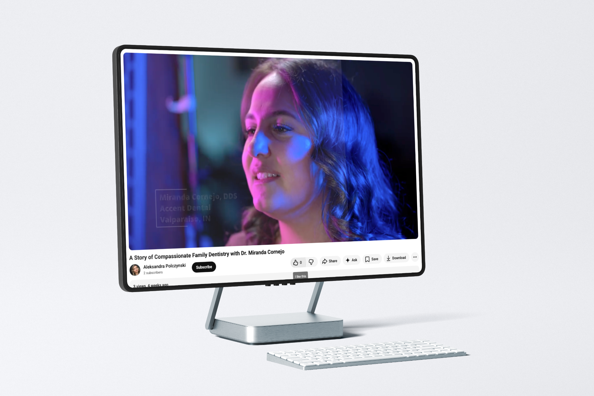 A computer monitor displaying a YouTube video of a person talking, set against a colorful backdrop.