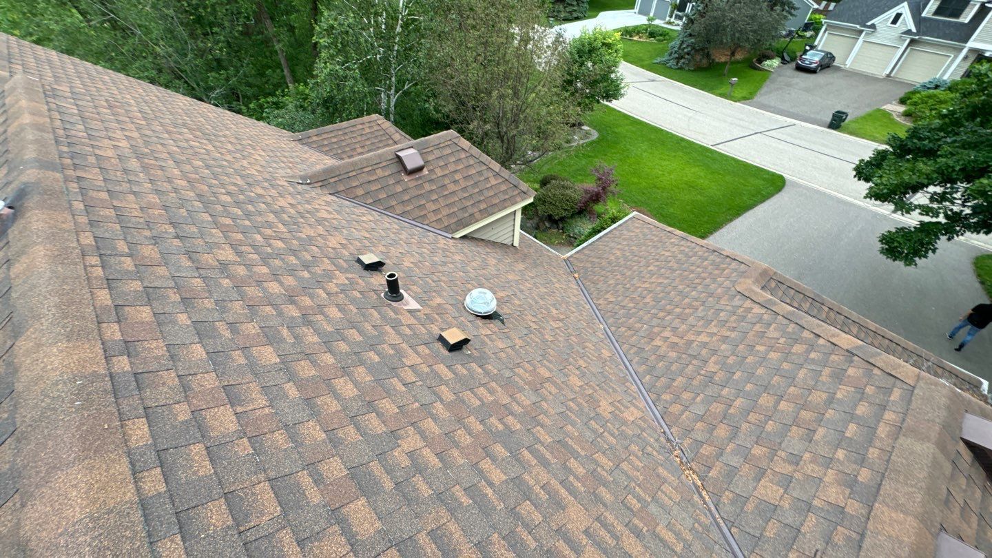 An aerial view of a roof of a house in a residential area.