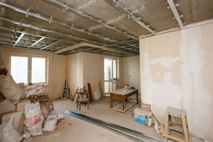a room under construction with a table and chairs in it