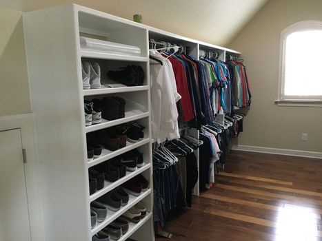 a walk in closet filled with lots of clothes and shoes
