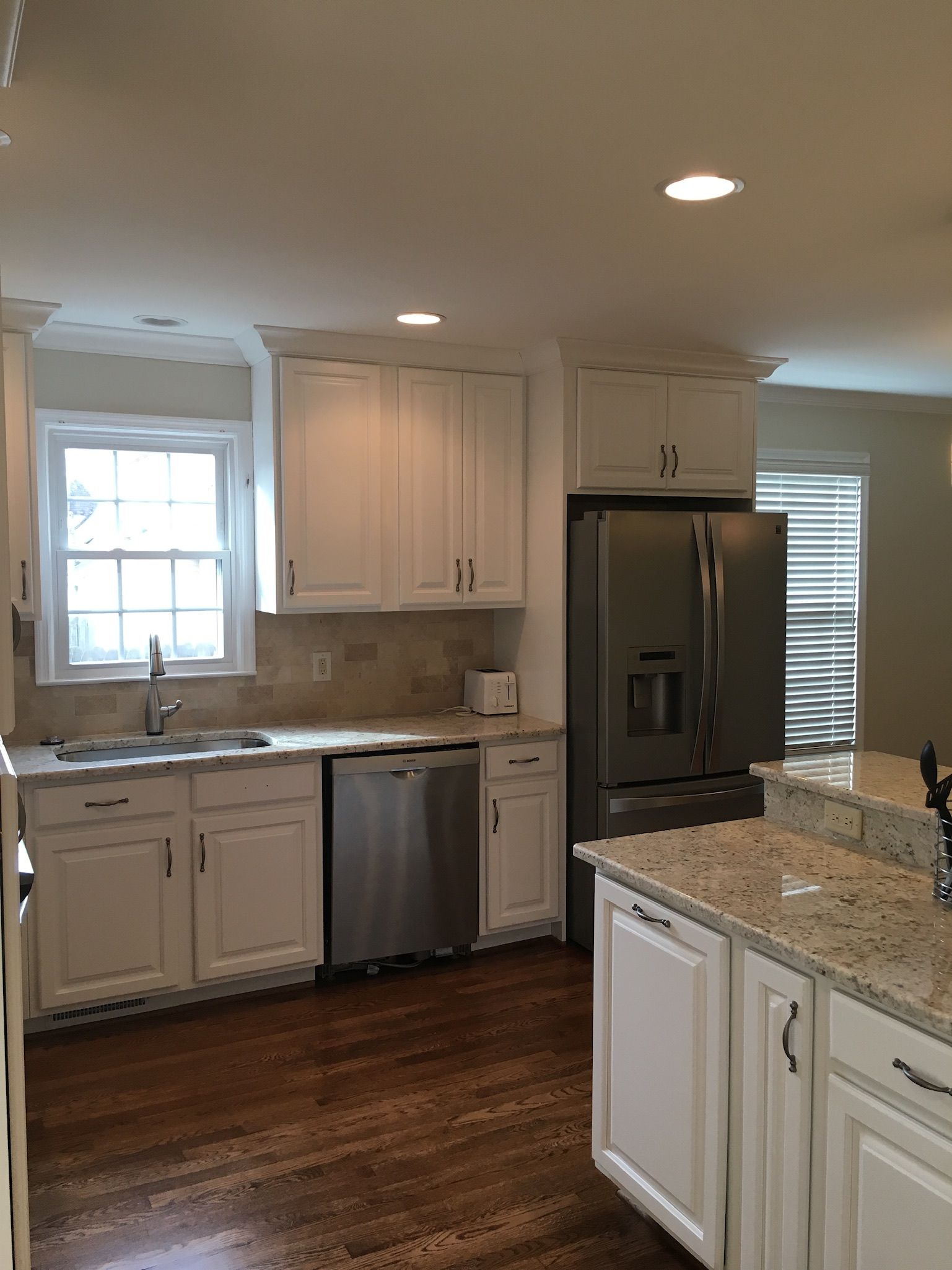 a kitchen with white cabinets and granite counter tops