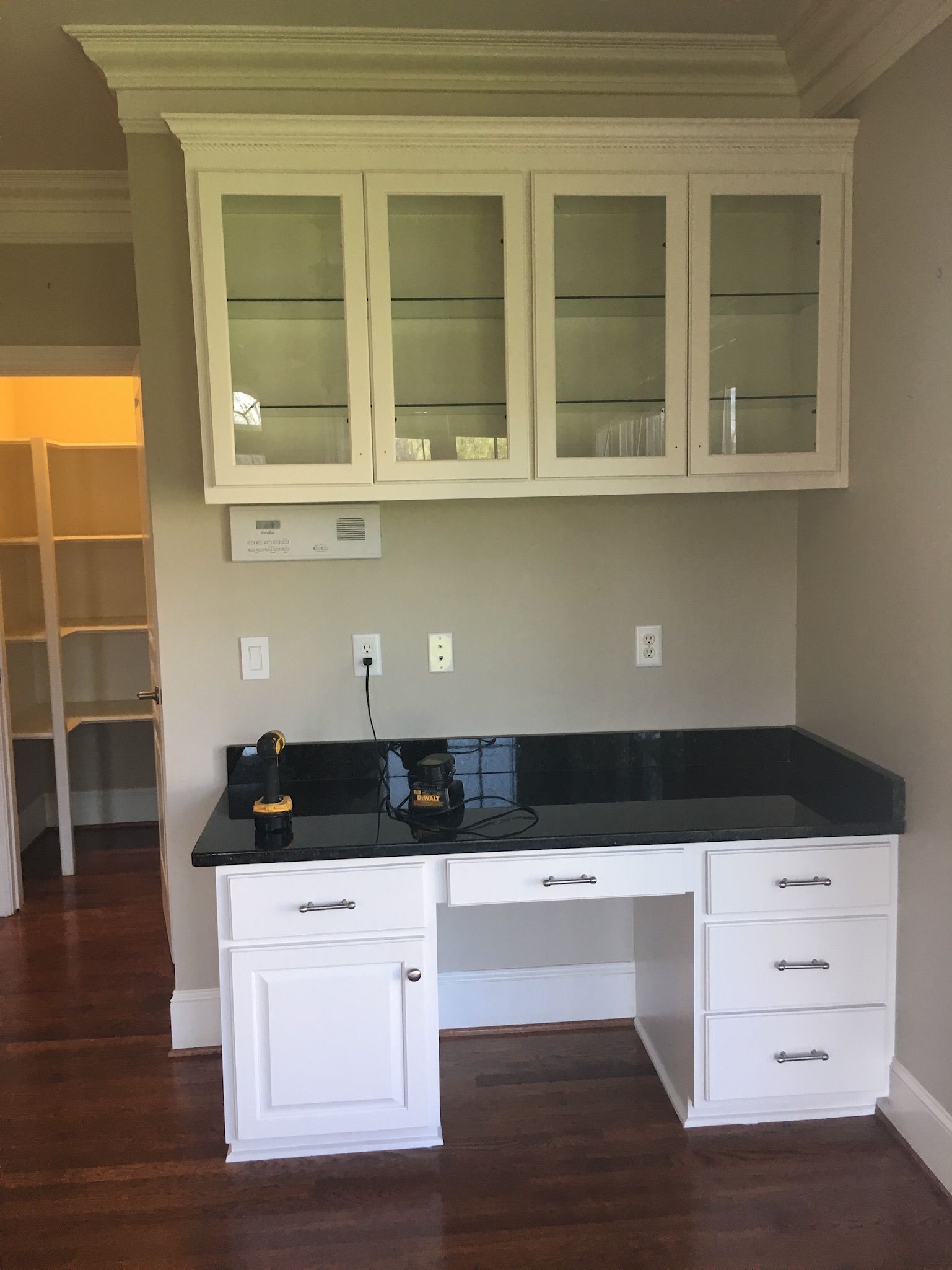 an empty room with a desk and glass cabinets