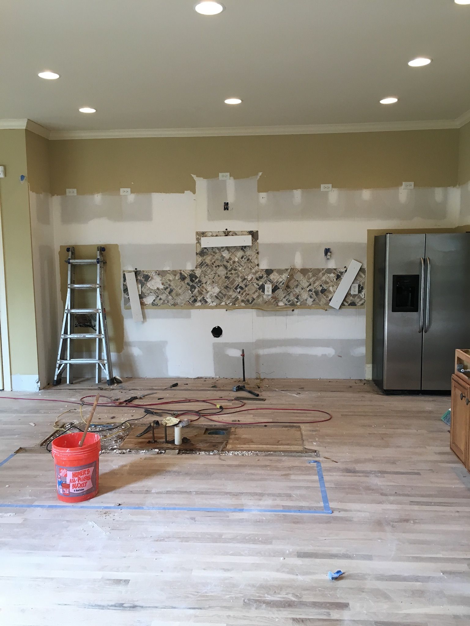 a kitchen under construction with a bucket of paint on the floor