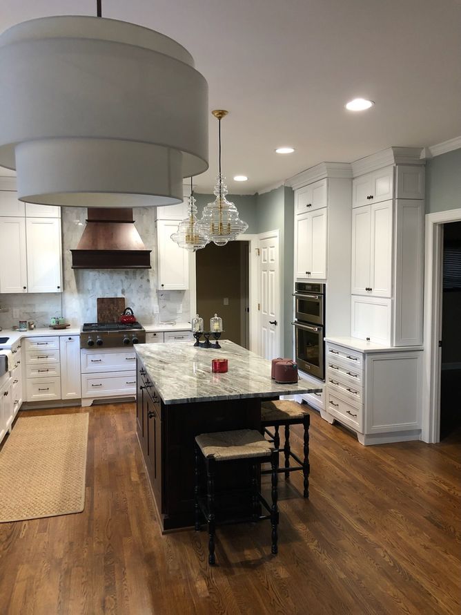 a kitchen with white cabinets and a large island in the middle