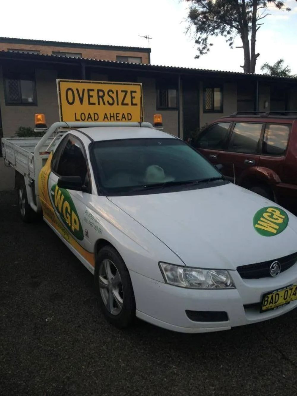 A White Truck With an Oversize Load Ahead Sign on Top — Wallamore Grading & Packaging In Wallamore, NSW