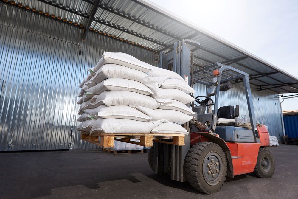 A Forklift is Carrying a Pallet of Bags in a Warehouse — Wallamore Grading & Packaging In Gunnedah, NSW