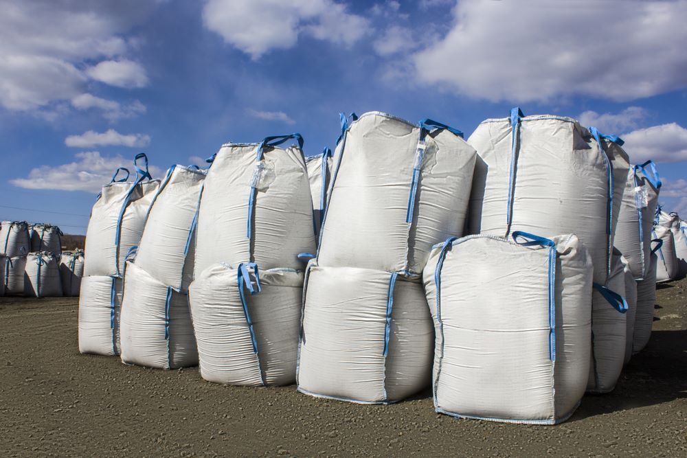 A Bunch of White Bags Are Stacked on Top of Each Other on the Ground — Wallamore Grading & Packaging In Gunnedah, NSW