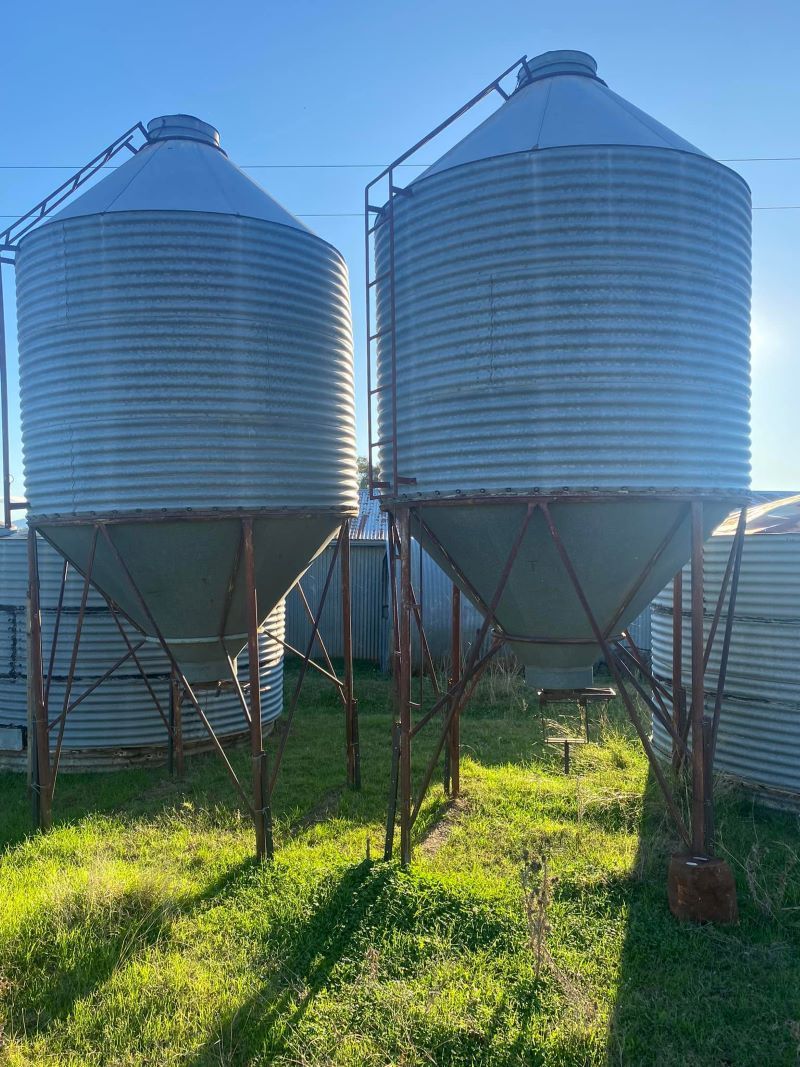Two Silos Are Sitting Next to Each Other in a Grassy Field — Wallamore Grading & Packaging In Wallamore, NSW