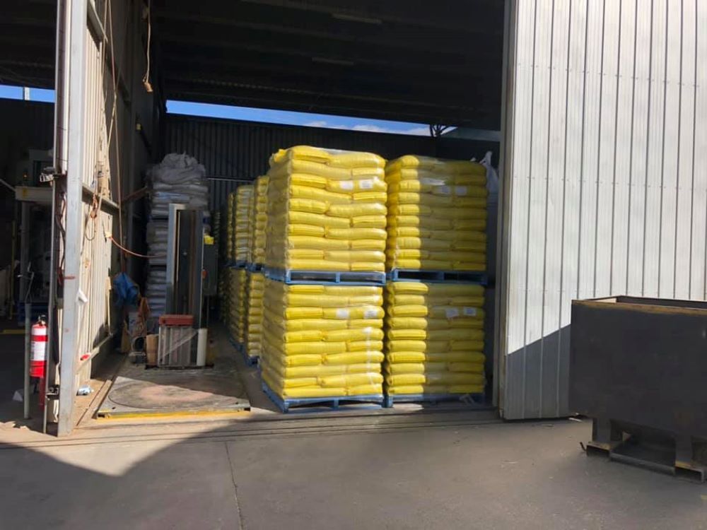 A Warehouse Filled With Lots of Yellow Bags on Pallets — Wallamore Grading & Packaging In Wallamore, NSW