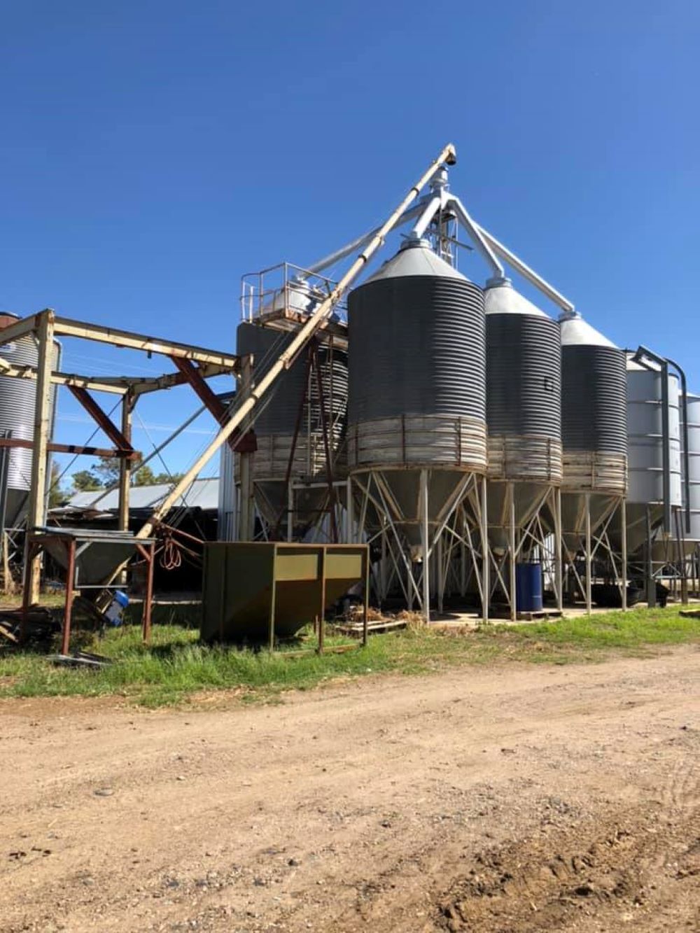 A Row of Silos Sitting on Top of a Dirt Road — Wallamore Grading & Packaging In Wallamore, NSW