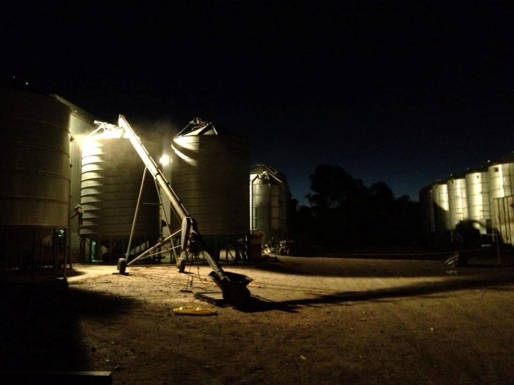 A Row of Silos Are Lit Up at Night — Wallamore Grading & Packaging In Wallamore, NSW