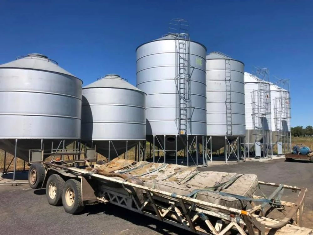 A Trailer is Parked in Front of a Row of Silos — Wallamore Grading & Packaging In Wallamore, NSW