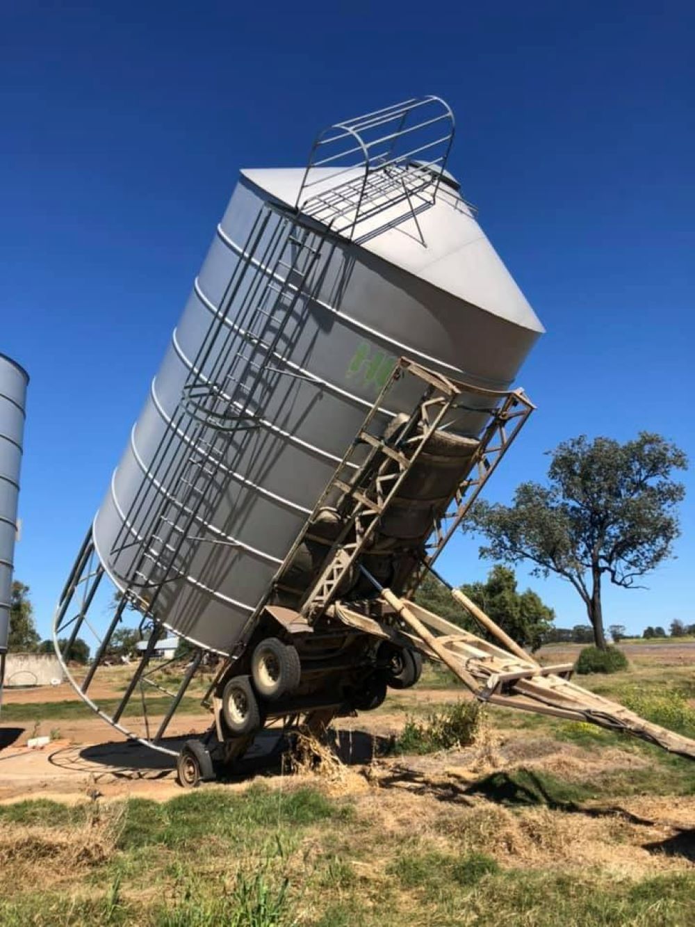 A Large Silo is Sitting on Top of a Trailer in a Field — Wallamore Grading & Packaging In Wallamore, NSW
