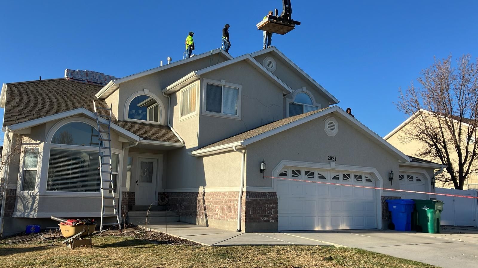 A large building is being built with scaffolding against a sunset sky.