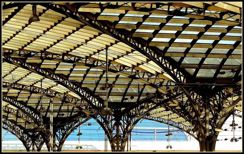 The ceiling of a building with arches and a blue sky in the background