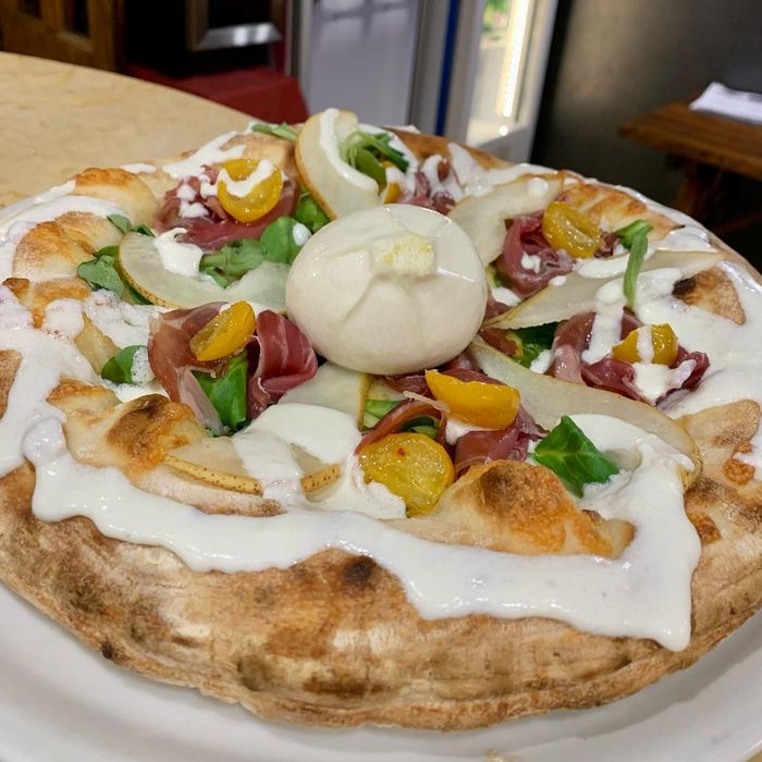 Assortimento di pizze artigianali con diverse farciture su tavolo rustico.