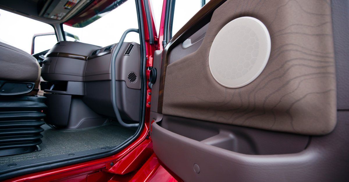 A bright red commercial truck with its passenger-side door open, revealing a clean and empty interior.