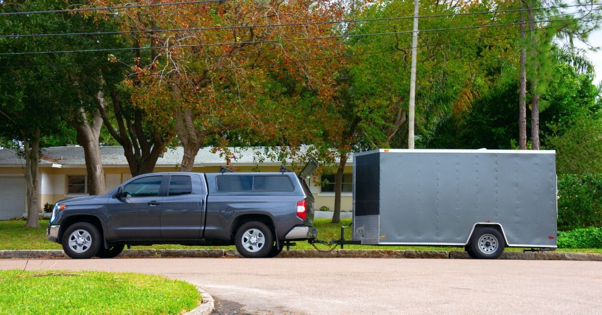 A dark gray truck parked on a residential street during the daytime.