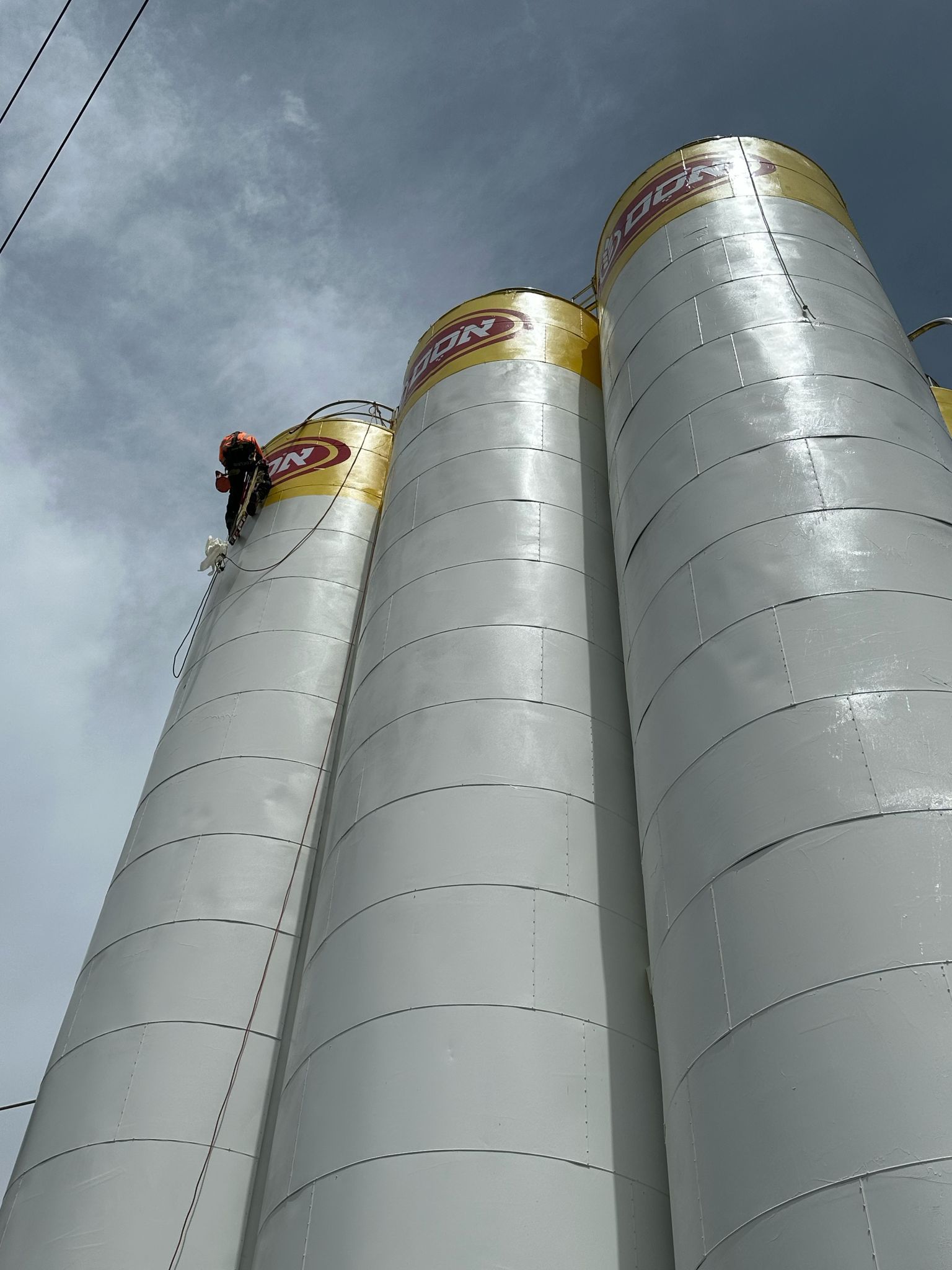 יישום צבע חוץ בסילו וחידוש לוגו בגובה באמצעות גלישת סנפלינג