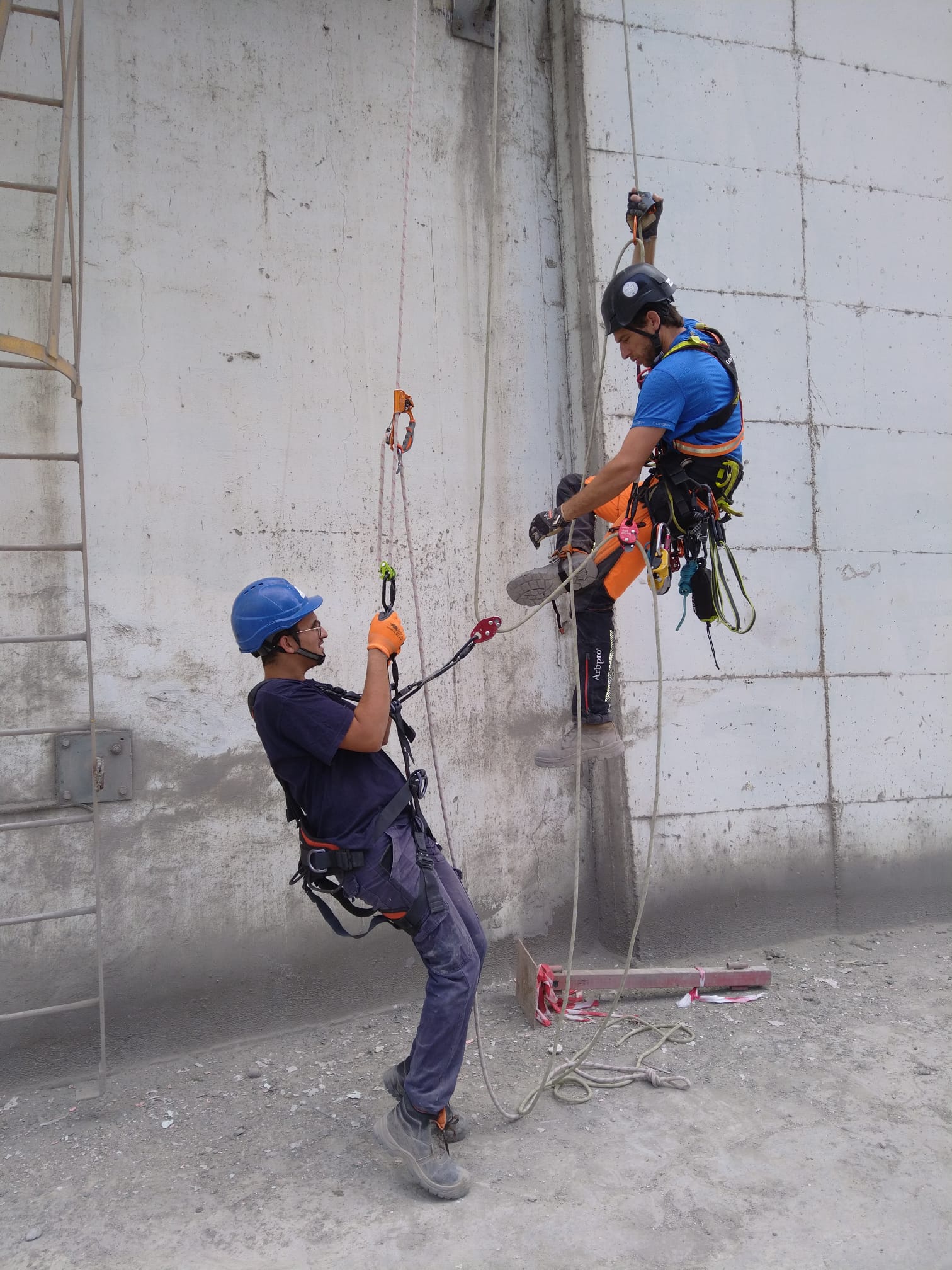 העובדים בגלישת סנפלינג בעת ביצוע עבודת צבע חוץ במפעל