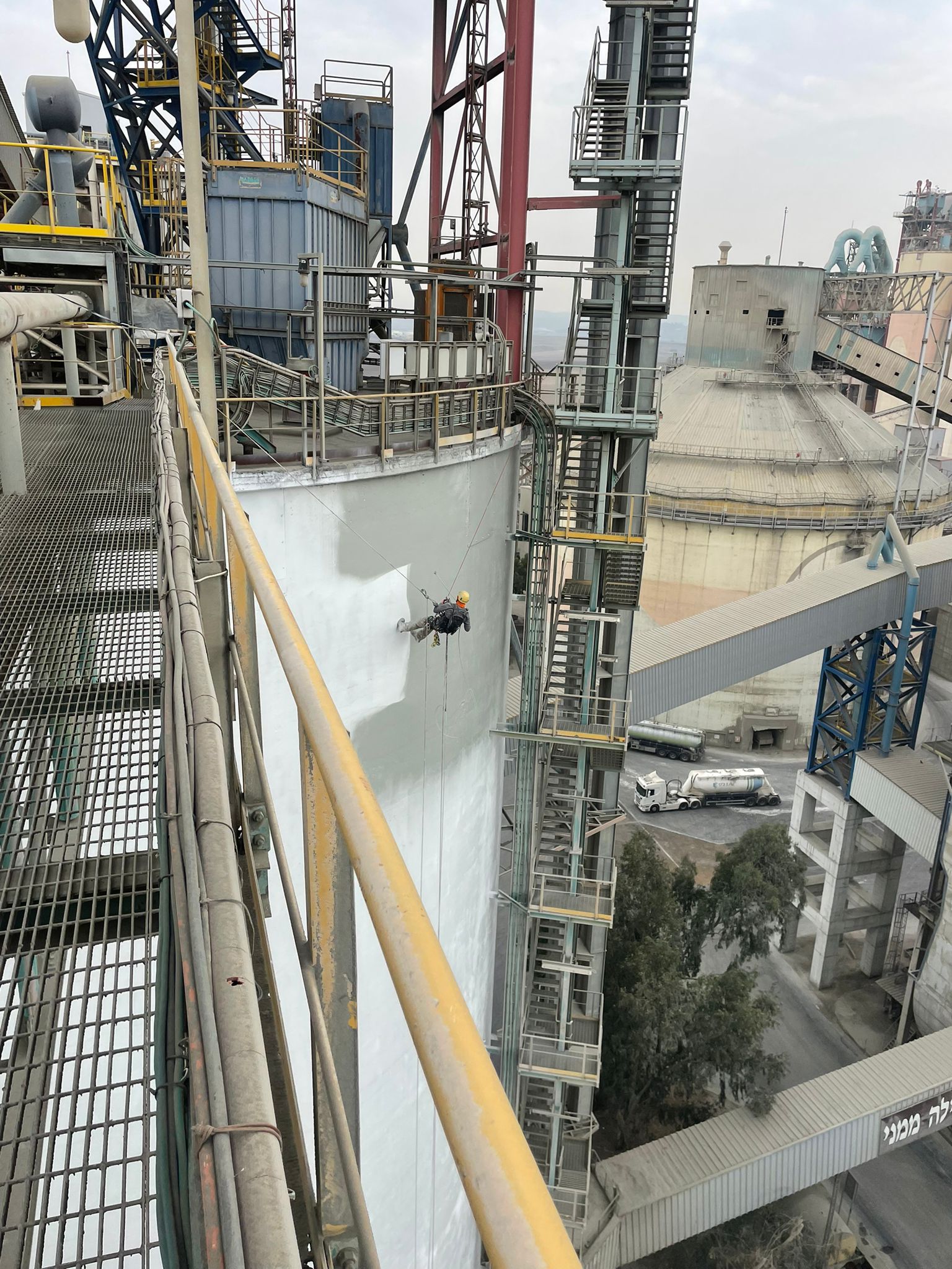 פרש אנד קלין במהלך ביצוע עבודות צבע חוץ לסילוסים בגלישת סנפלינג תוך שימוש במכשיר איירלס