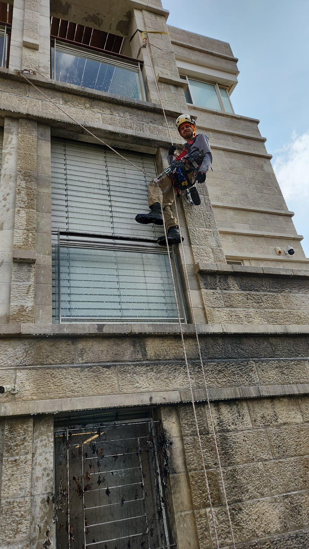 ניקוי אבן חוץ ירושלמית בגלישת סנפלינג כחלק מעבודות שיקום נזקי שריפה
