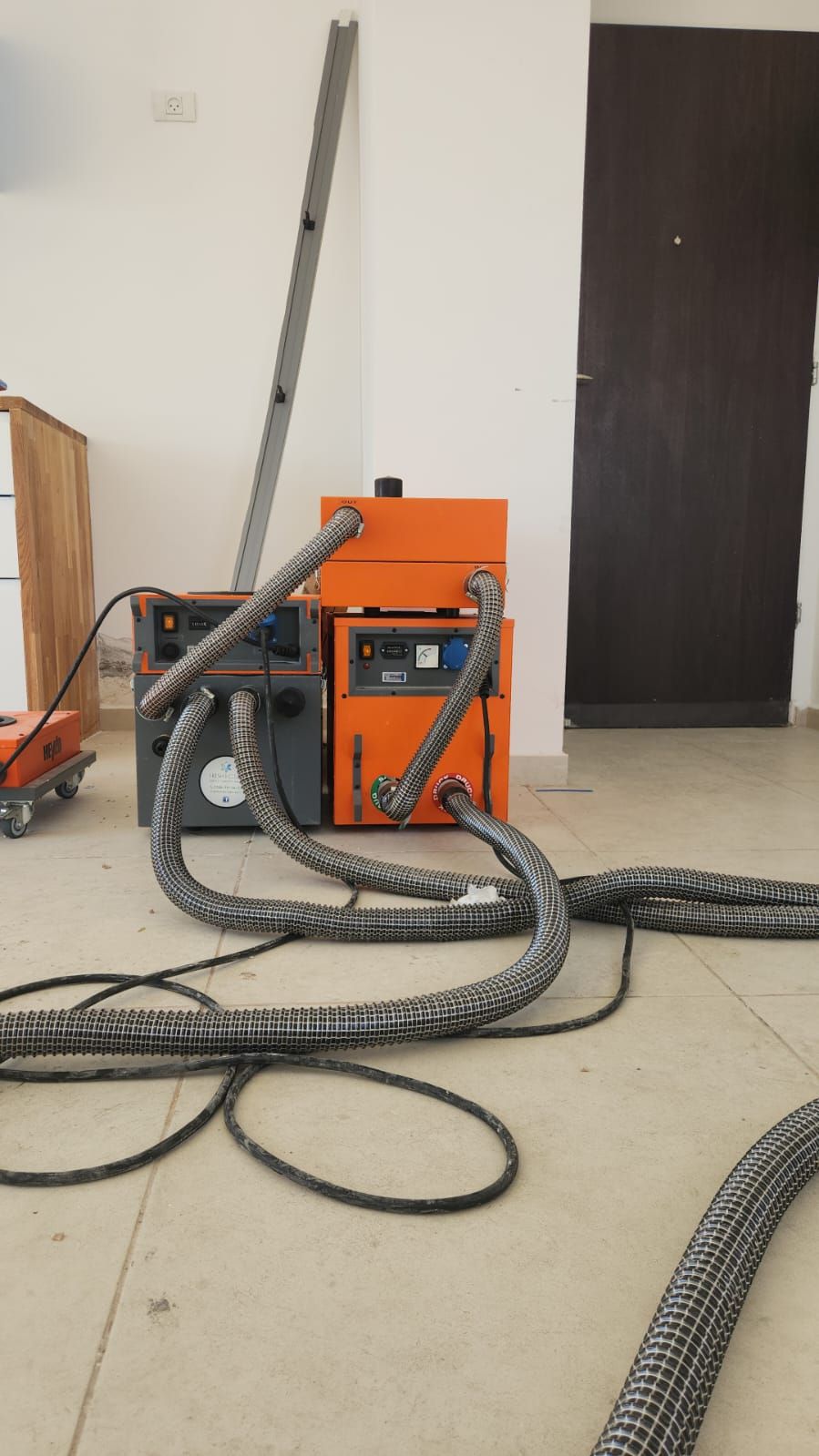 מכונות ייבוש תת רצפתי בפעולה כחלק משיקום נזק 