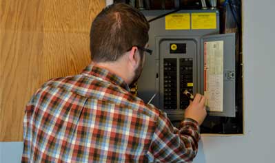 Man fixing fuse box —Electric Panel Installation in York, PA