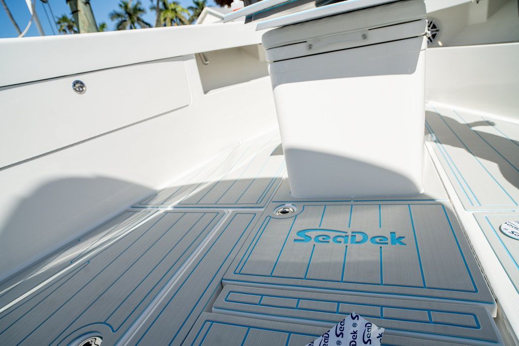 White and gray boat flooring with "Seadek" logo in turquoise.