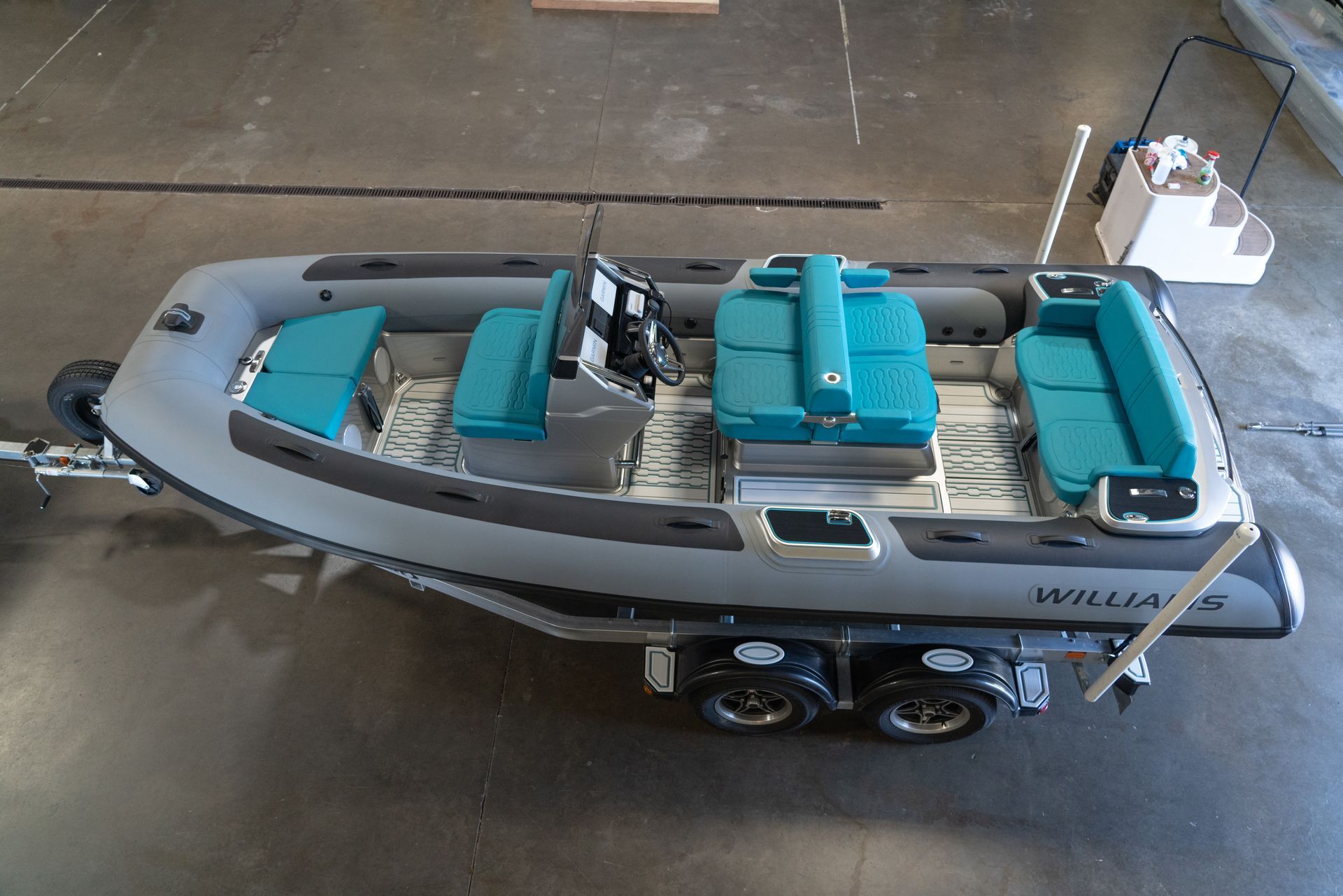 Gray and teal inflatable boat on a trailer, ready for transport.