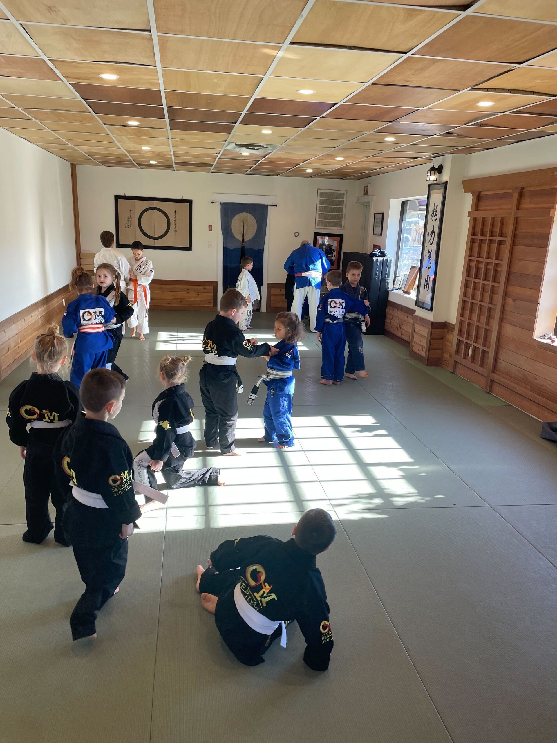 Students drilling Brazilian Jiu-Jitsu at OM Brazilian Jiu JItsu & Judo in Northport, NY to build strength and flexibility
