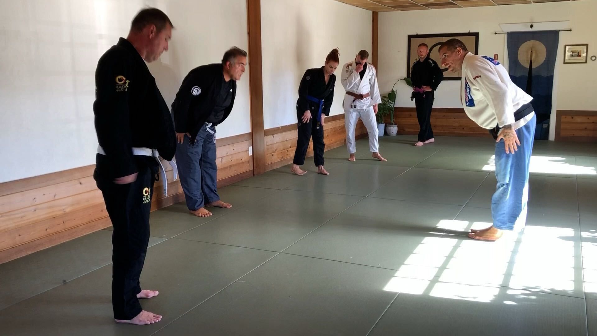 Adults practice Brazilian Jiu-Jitsu drills at OM Brazilian Jiu JItsu & Judo in Northport, NY to build calm focus.