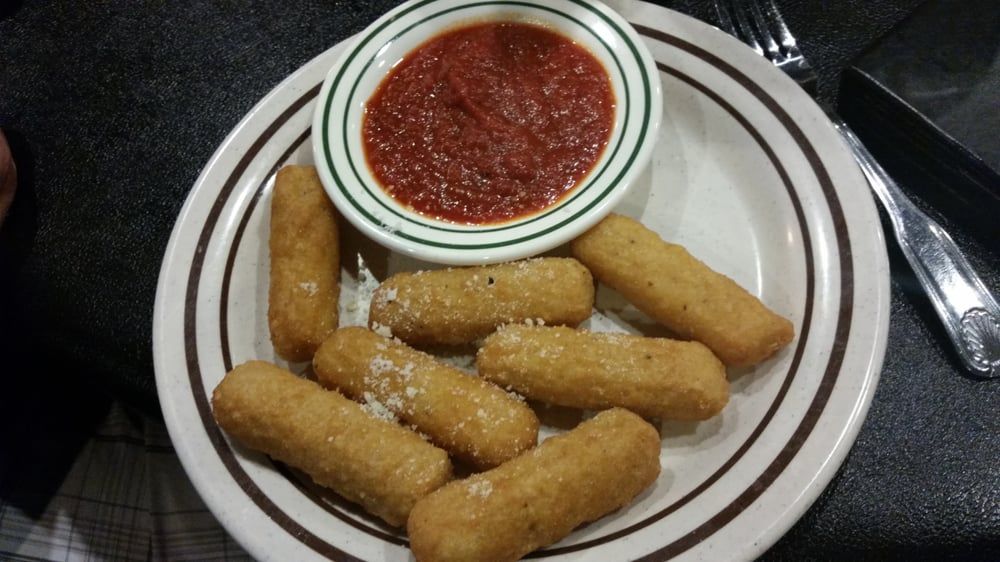a plate of mozzarella sticks with a dipping sauce