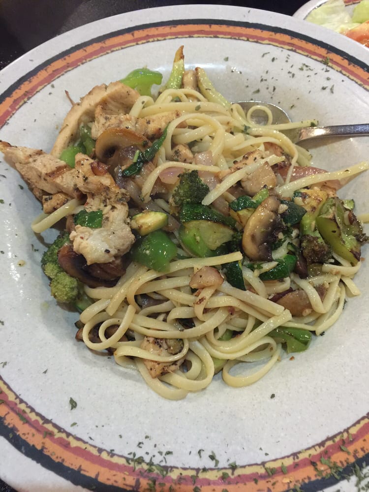 a white plate topped with noodles and vegetables with a spoon in it
