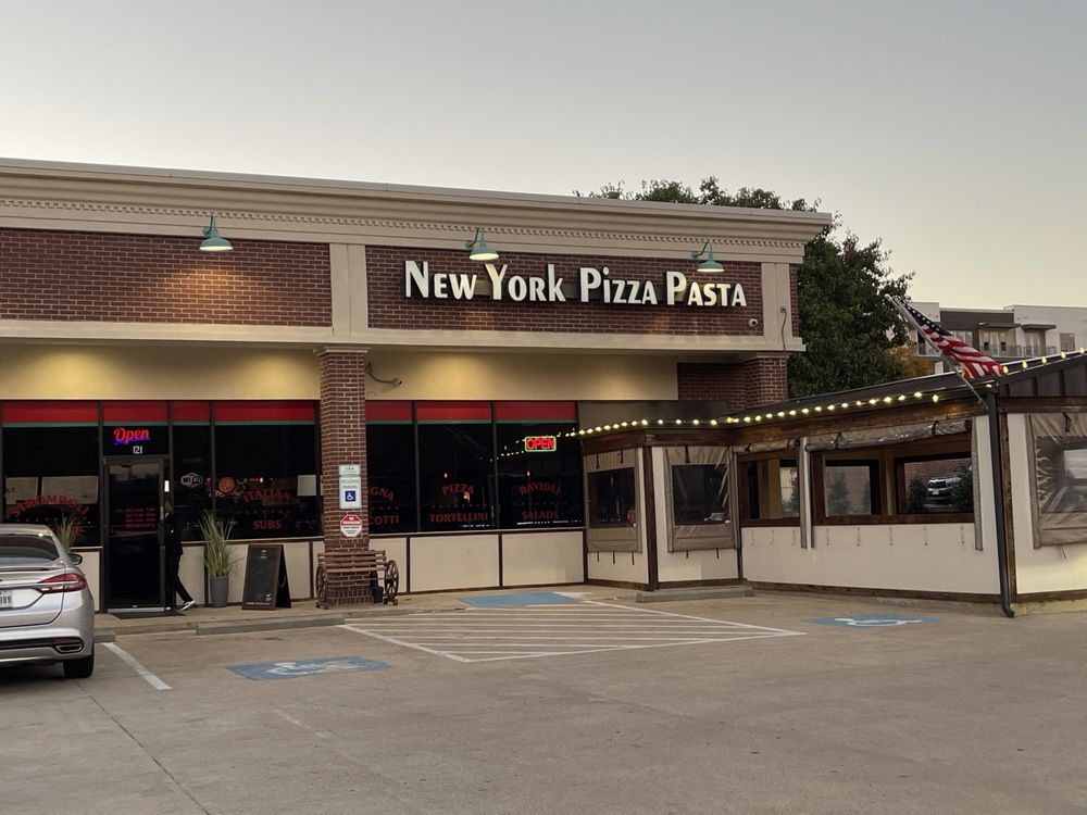 a car is parked in front of a new york pizza pasta restaurant