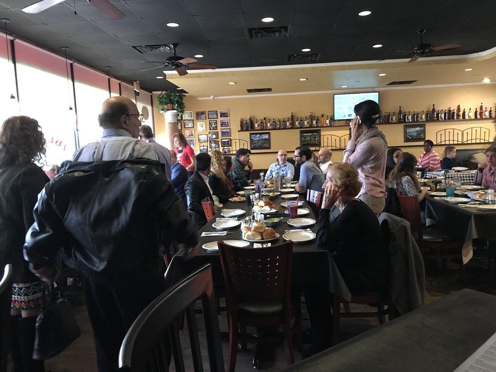 a group of people are sitting at tables in a restaurant .