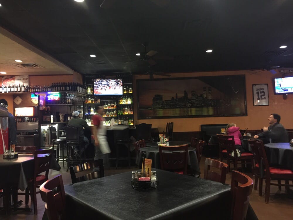 the inside of a restaurant with tables and chairs and a bar .