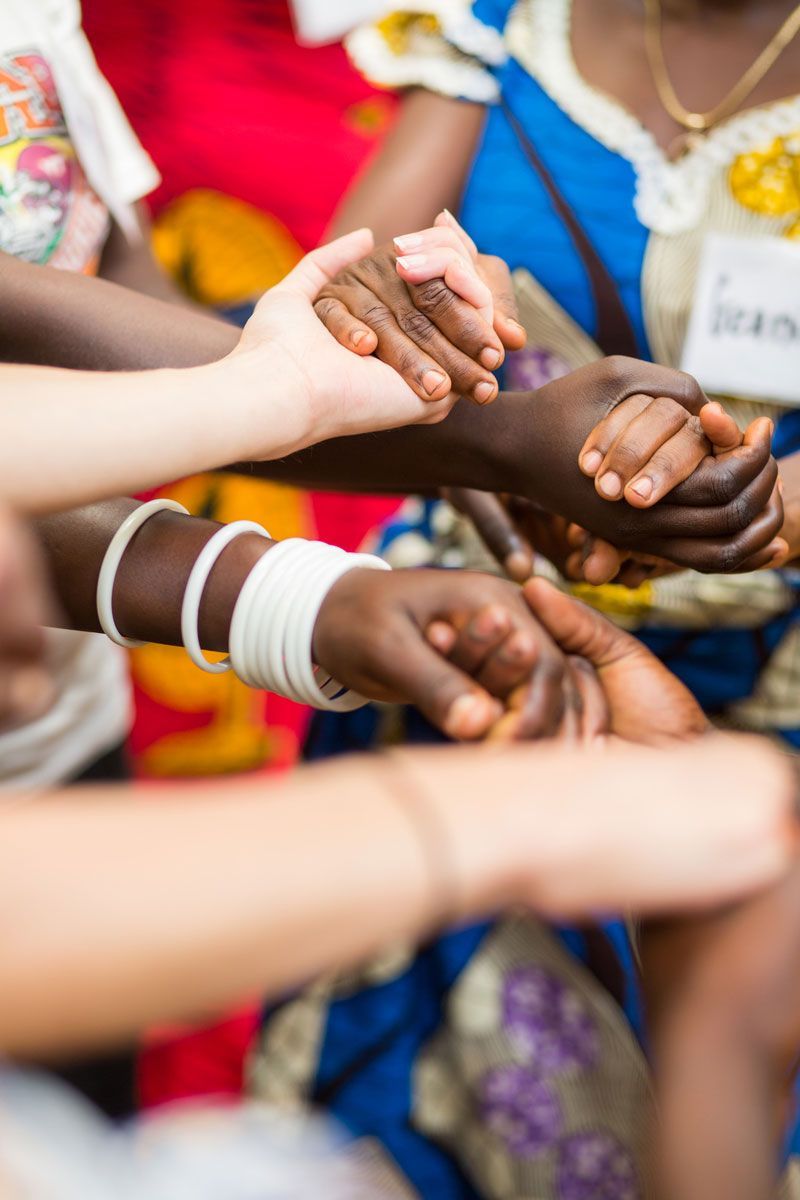 Hands of different skin tones clasped together in a circle.