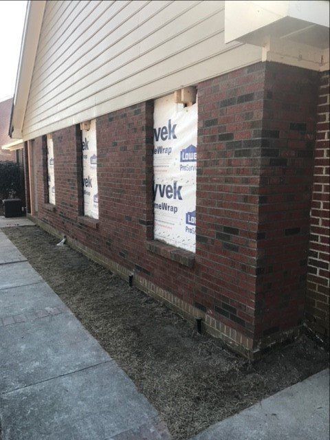 A brick building with velc wrap on the windows