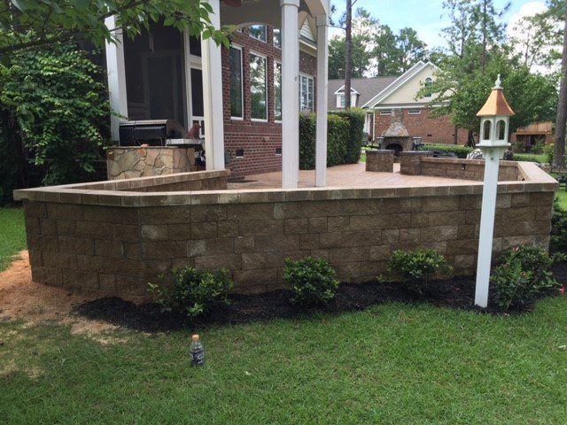 There is a brick wall in the backyard of a house.